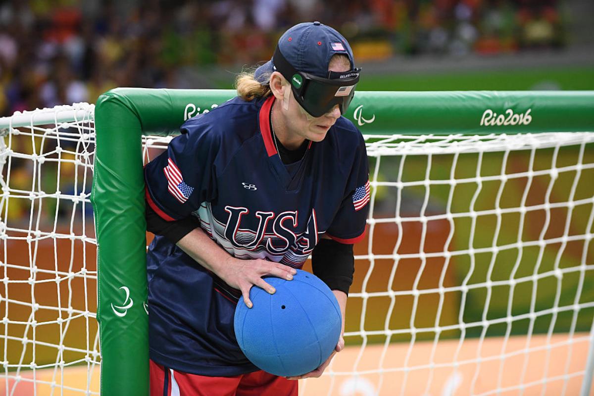 a female goalball player stands by the goal