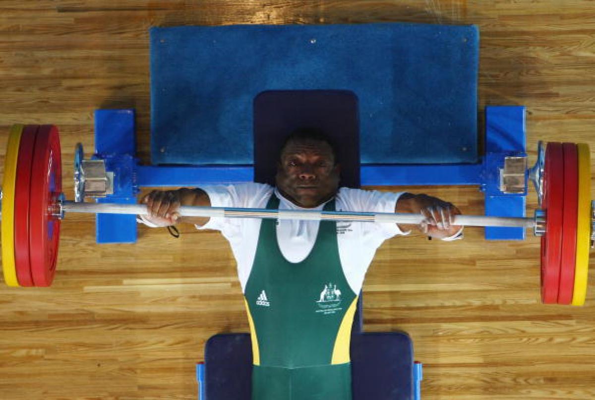 Male powerlifter lifts a bar