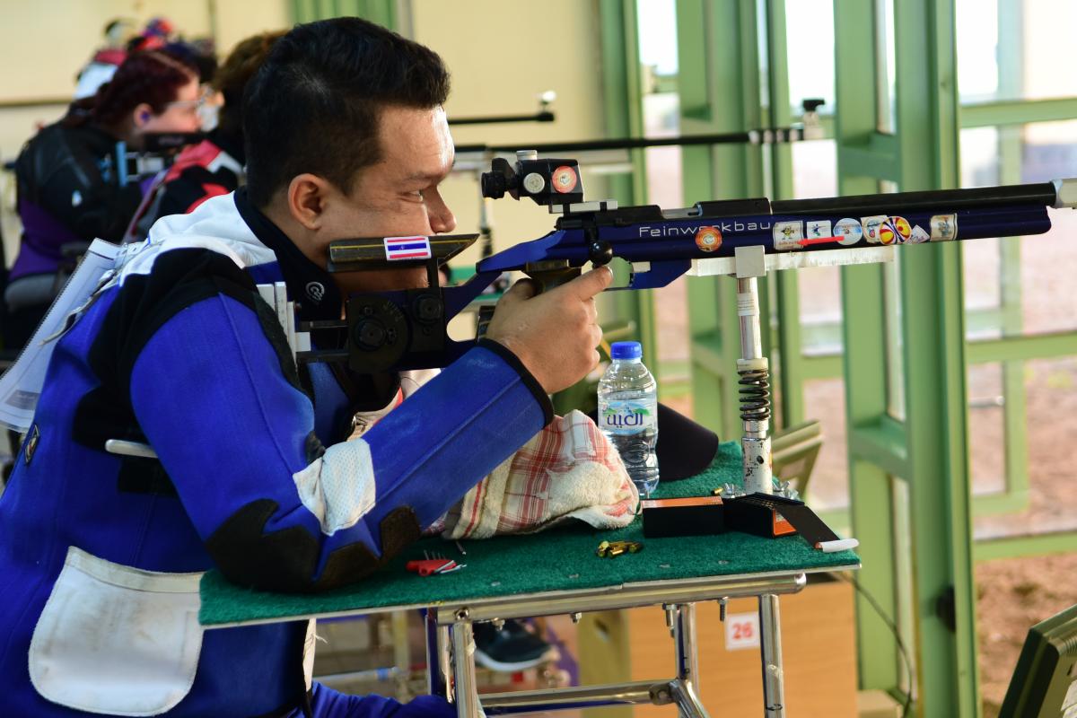 Man competing in R9 (mixed 50m rifle prone SH2) event 