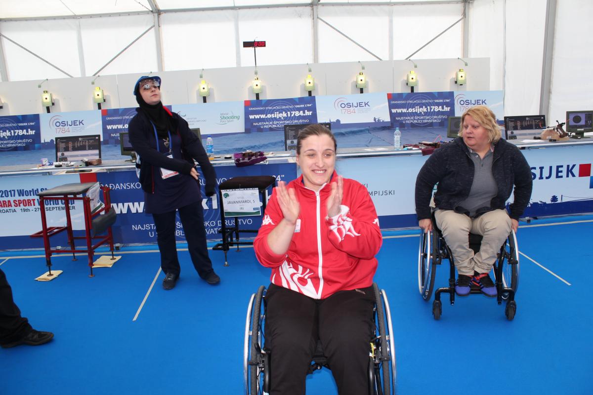 Female shooter in wheelchair smiles after winning