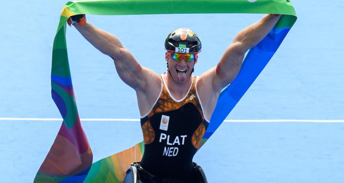a Para athlete sticks his tongue out as he crosses the finish line