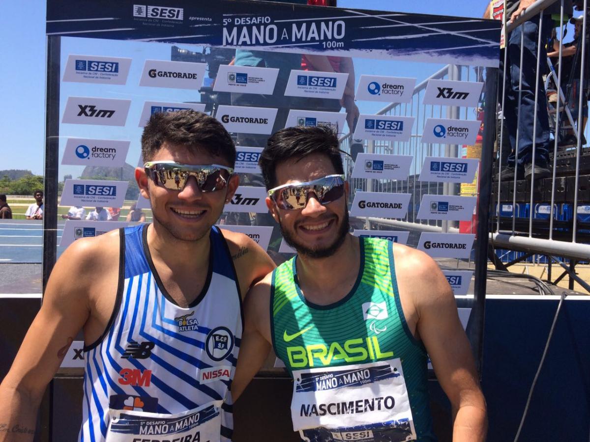 Two Brazilian para athletes smile with their arms around eachother