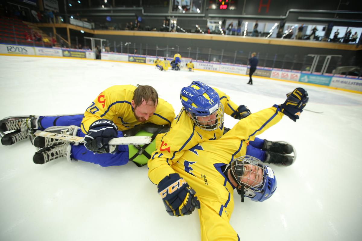 Para ice hockey players celebrate on the ice