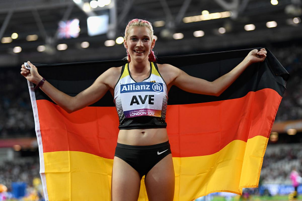 Lindy Ave announced German Youth Para athlete of the Year Person smiling and posing with the flag of Germany