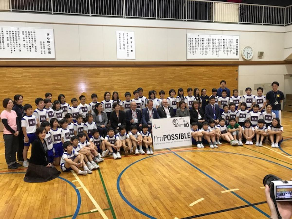 Children from the Akasaka Elementary School pose for picture in a goalball court with representatives from the IPC, NPC Japan and Nippon Foundation