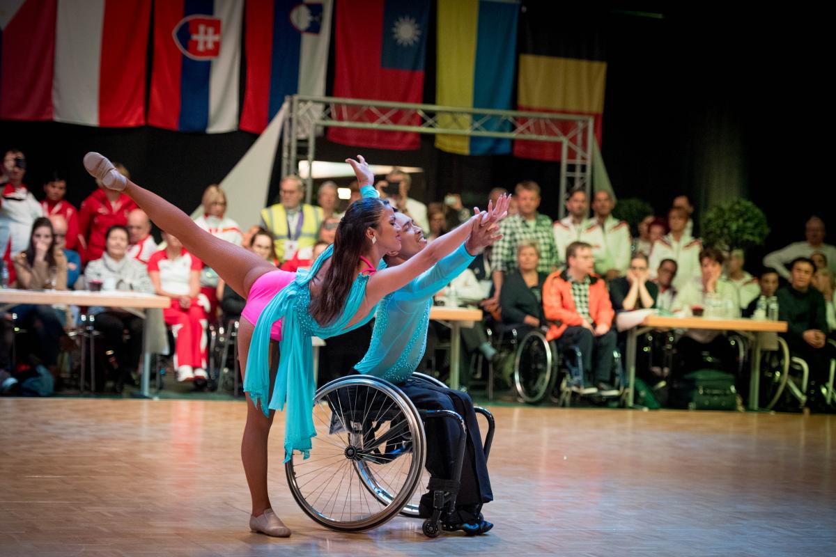 Man in wheelchair and woman standing dancer dance