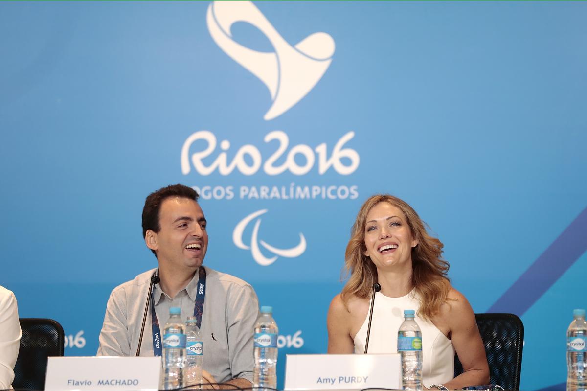a man and a woman answering questions at a press conference