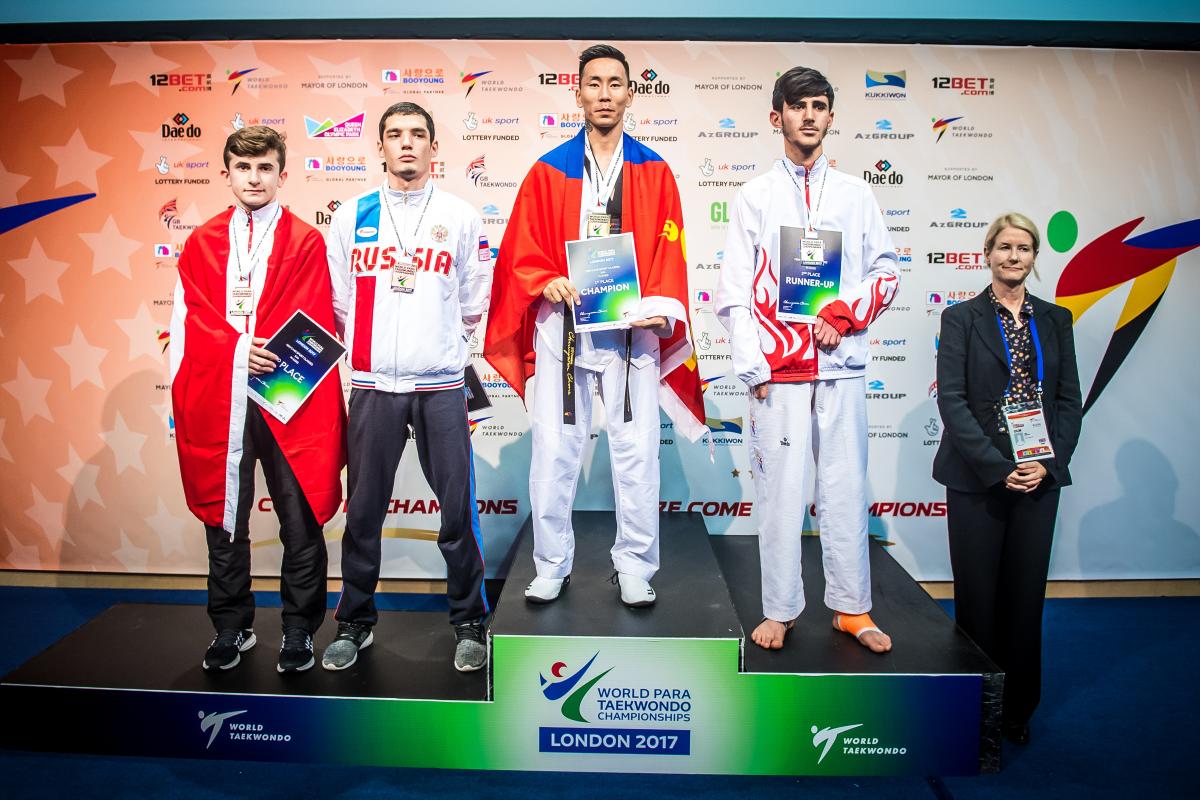 a group of Para taekwondo fighters stand on the podium