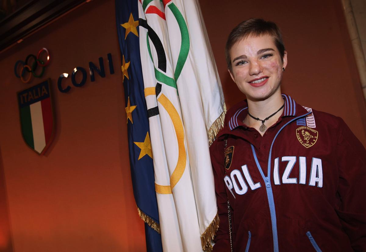 an female Para athlete smiles in front of an Italian flag