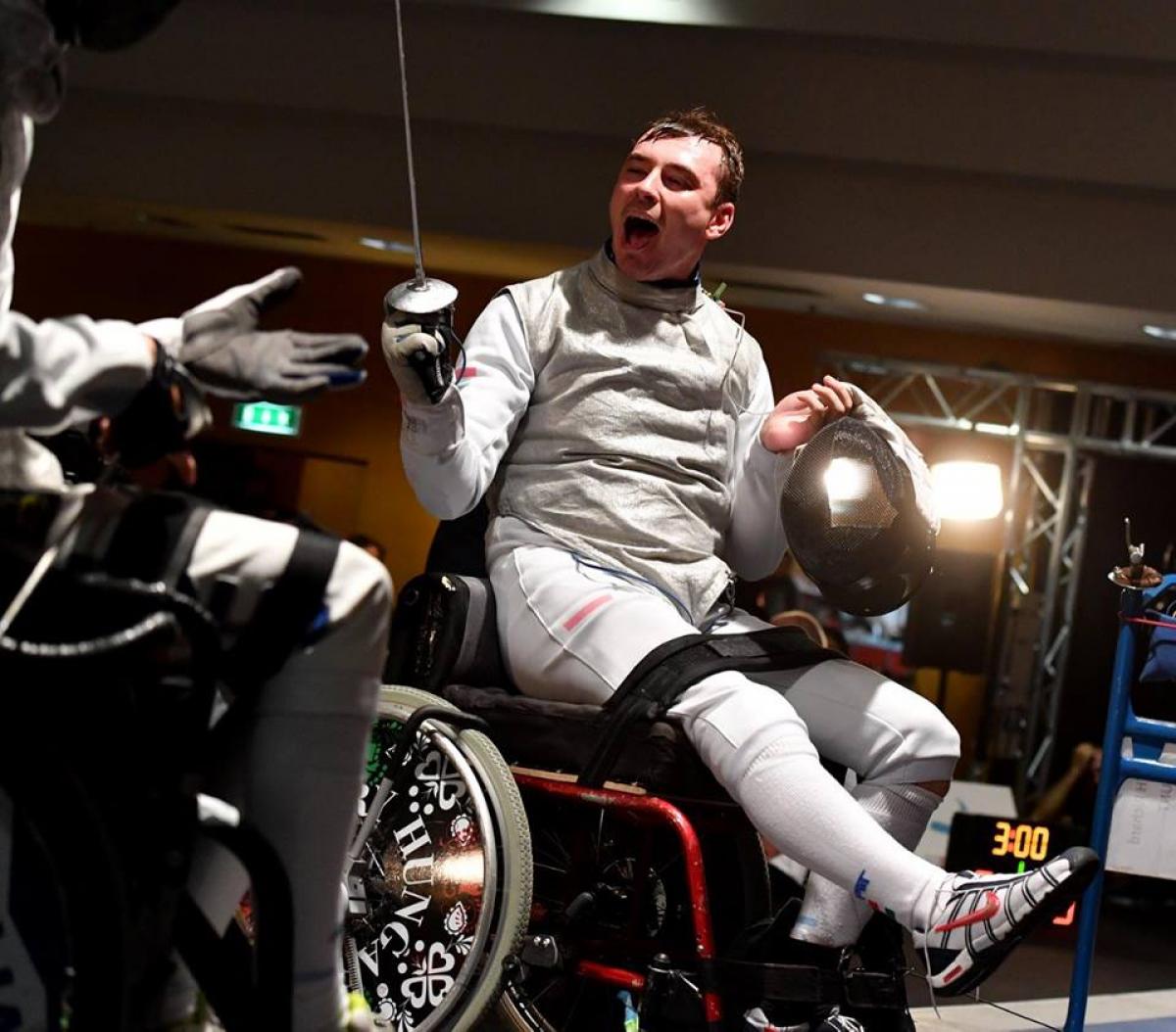 a wheelchair fencer celebrates his victory