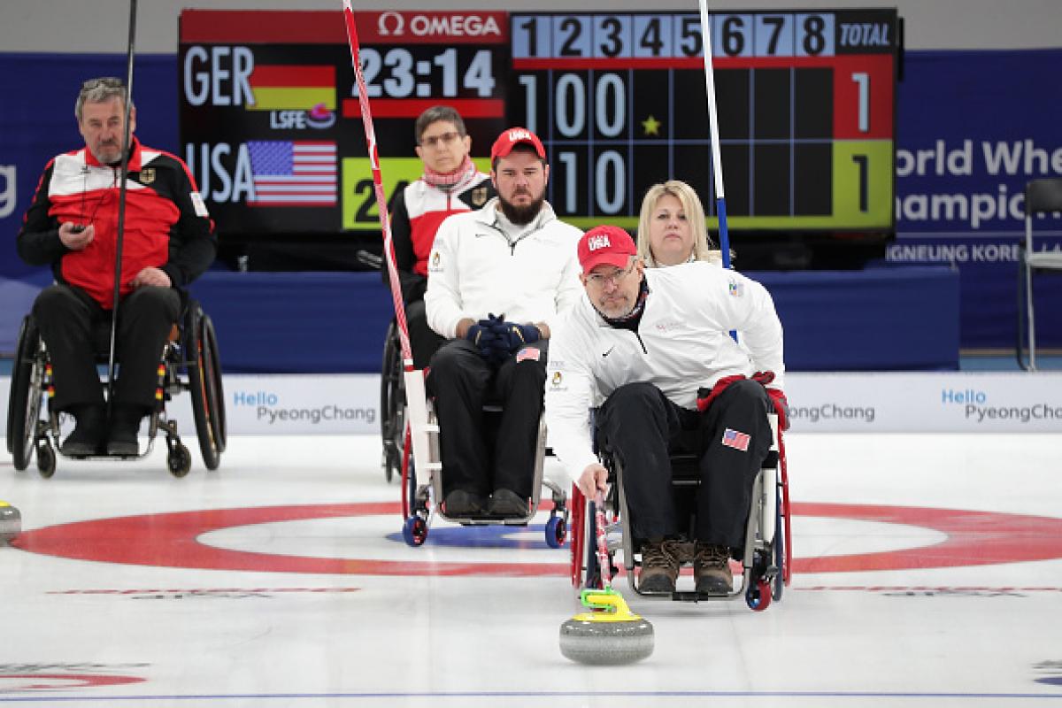 Wheelchair curlers competing on the ice