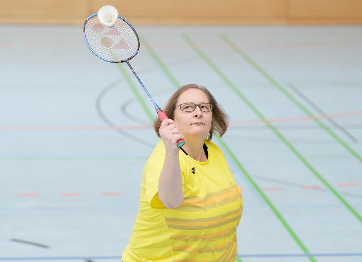 a female Para badminton player goes for a shot