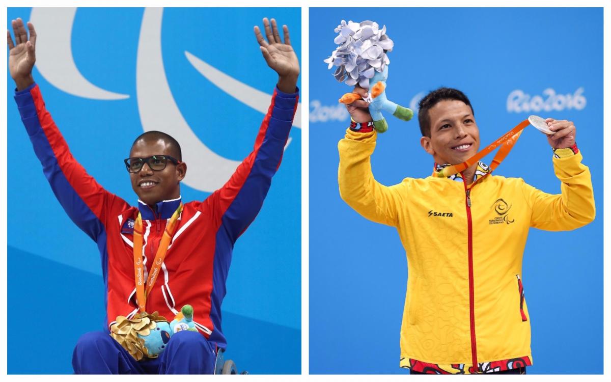 two male Para swimmer raise their arms on the podium