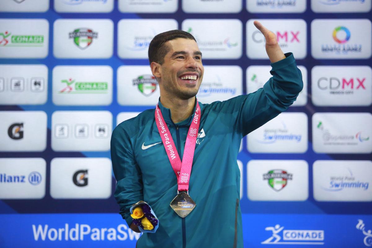 a male Para swimmer celebrates on the podium