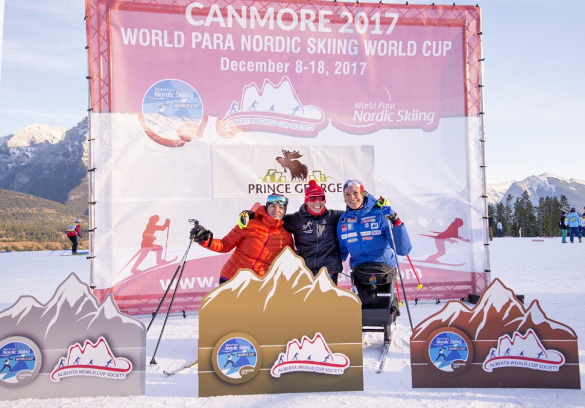 Podium shot of Andrea Eskau, Marta Zainullina and Birgit Skarstein embracing.