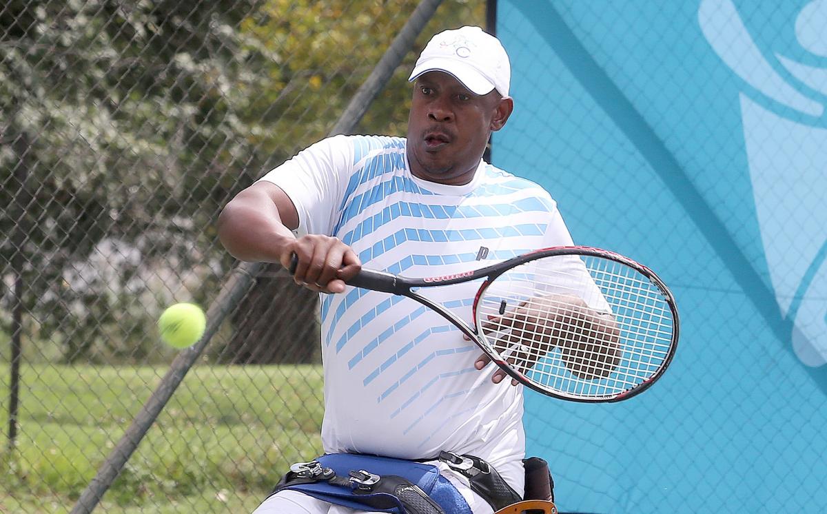 a male wheelchair tennis player takes a shot