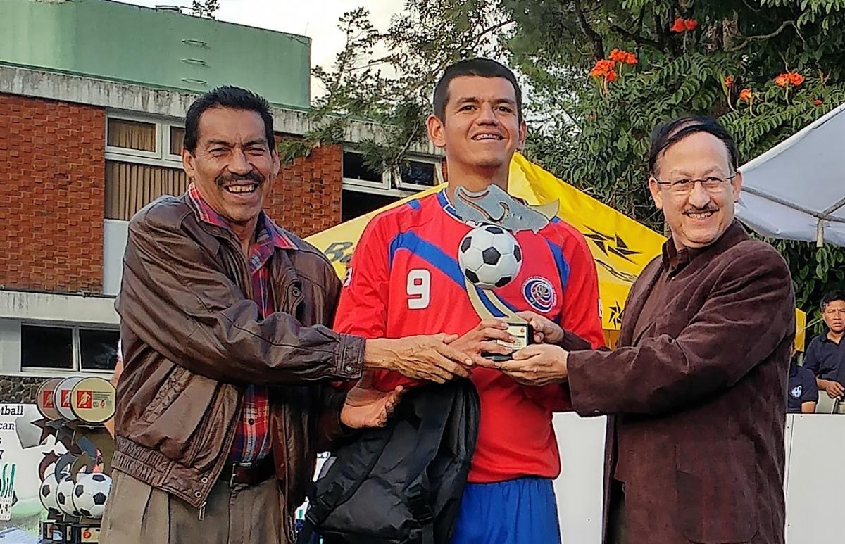 a blind footballer with his trophy 