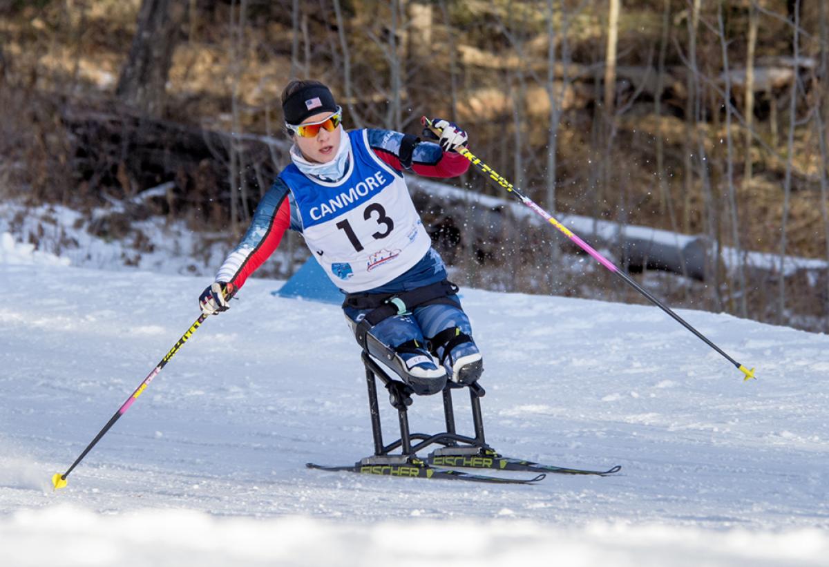 a female Para Nordic skier races towards the finish line