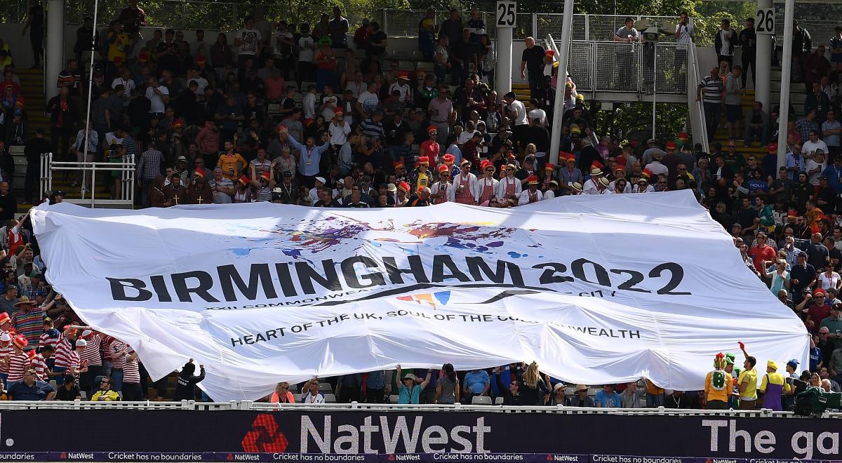 a huge flag is held up by a crowd of cricket supporters