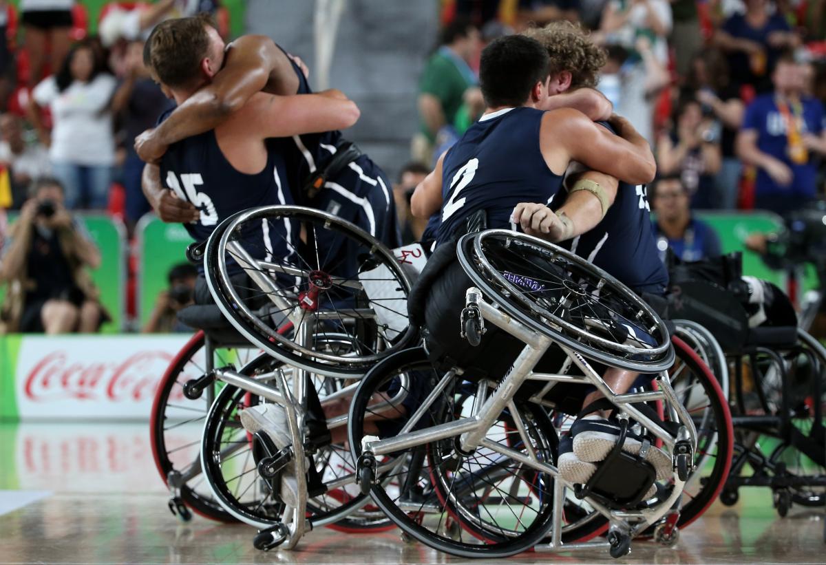male wheelchair basketball players hug eachother on the court