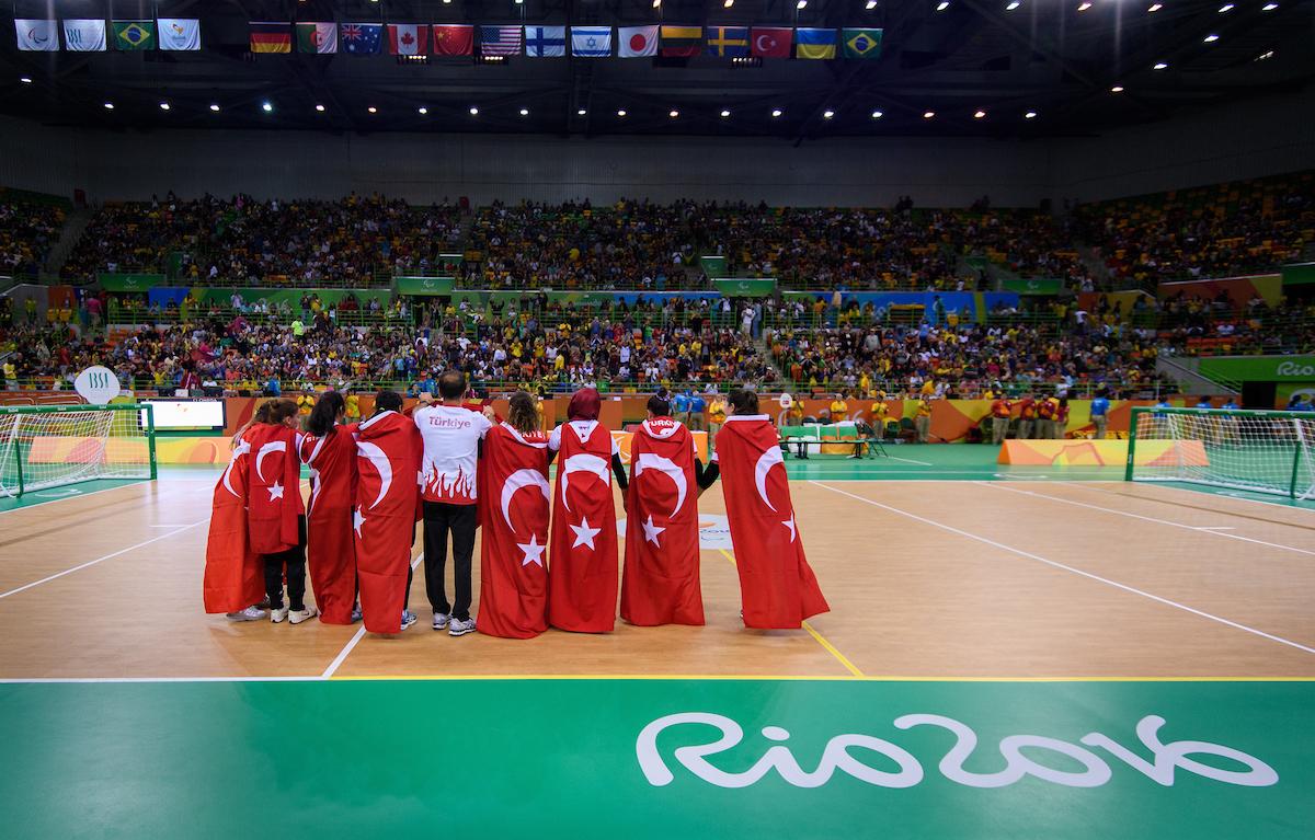 a group of women hug under the Turkish flag