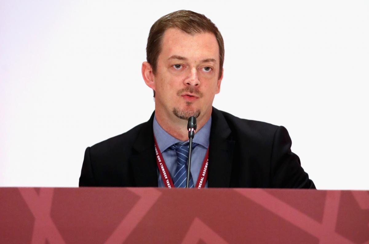 a man speaking at a desk