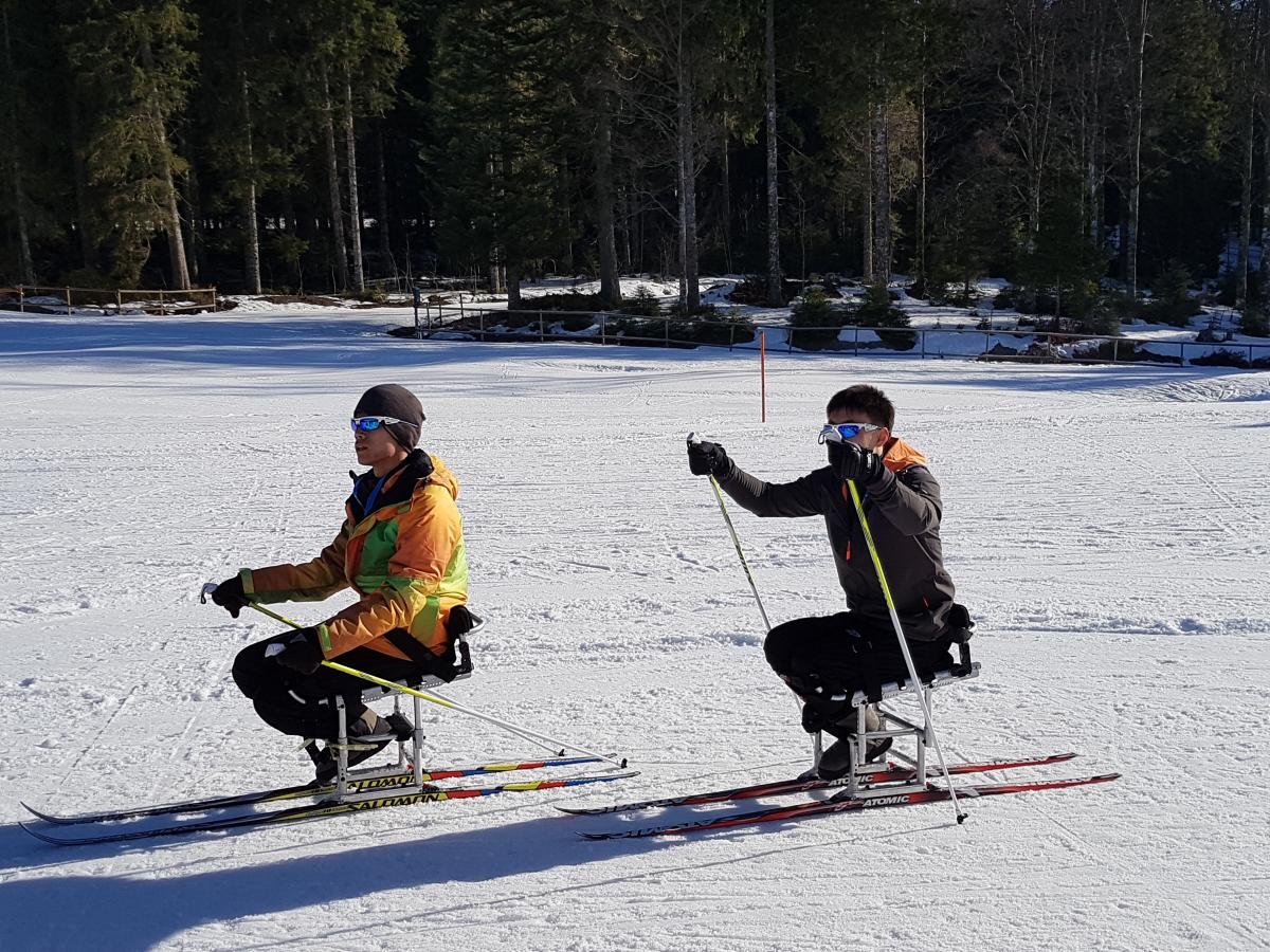 Jong Hyon Kim and Yu Chol Ma two male sit skiers on the snow