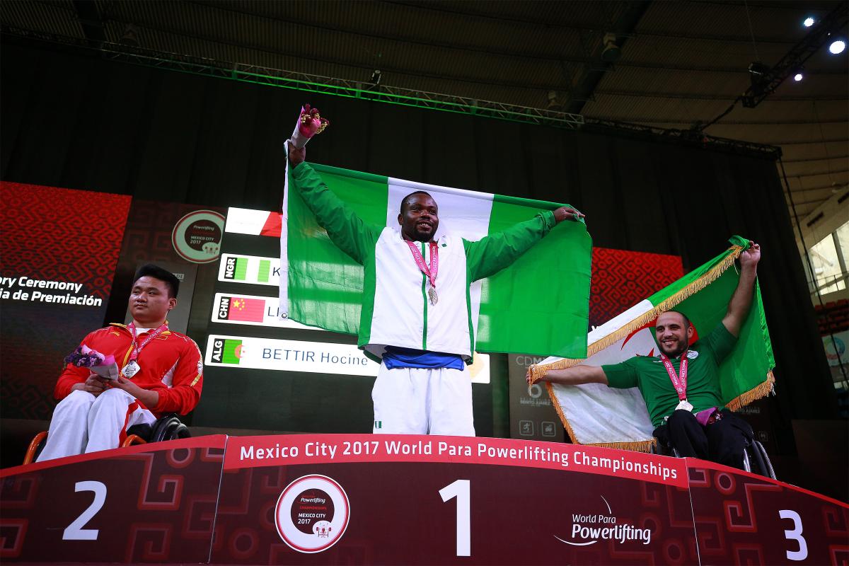 three male powerlifters on a podium