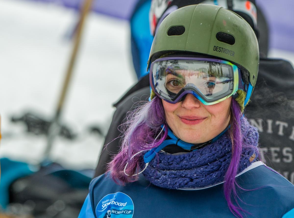 a female Para snowboarder smiles