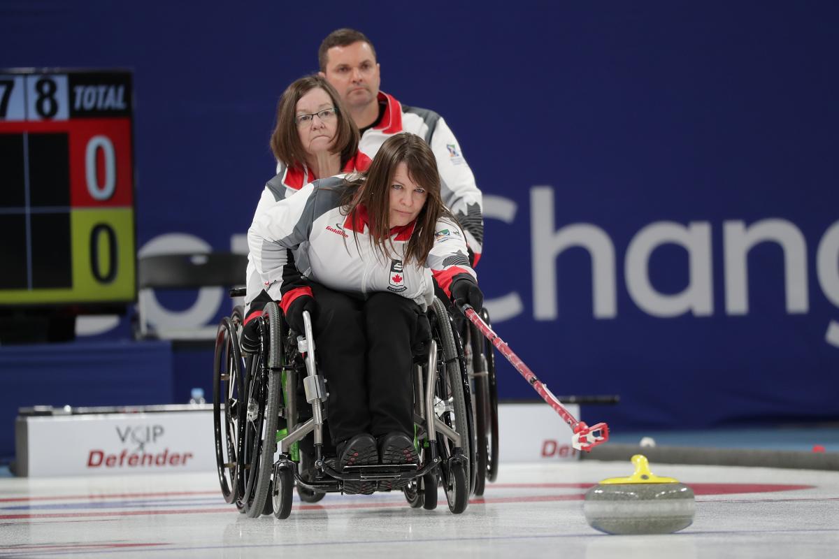 a female wheelchair curling releases a stone