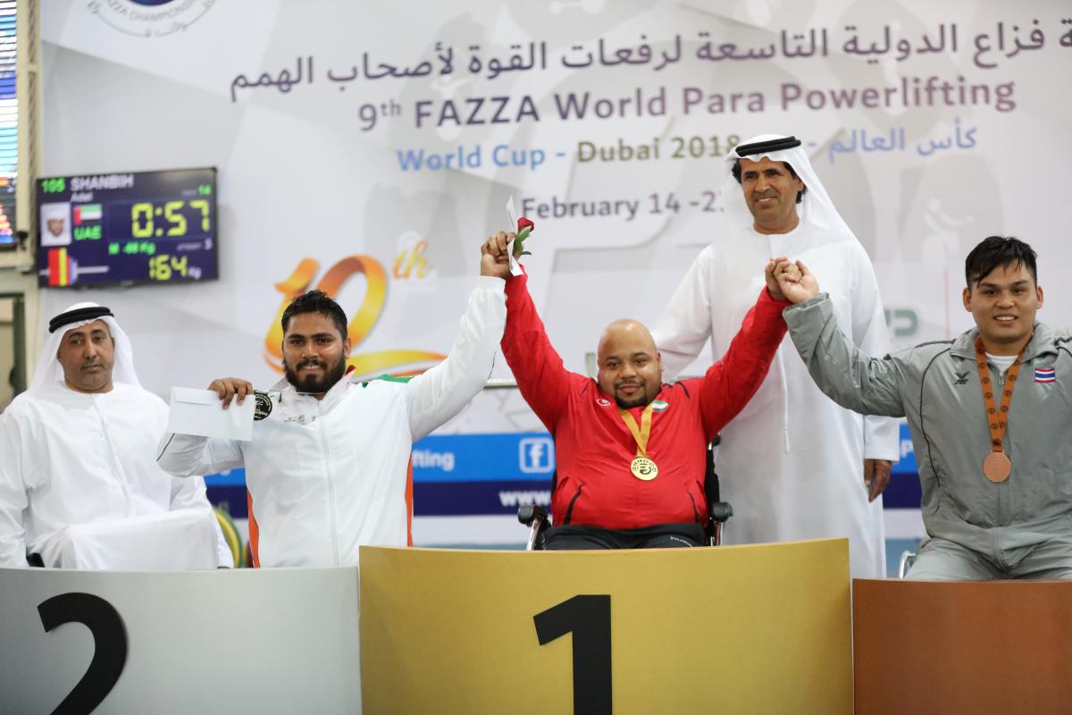 Adel Shanbih - Dubai 2018 three male powerlifters raise their arms on the podium