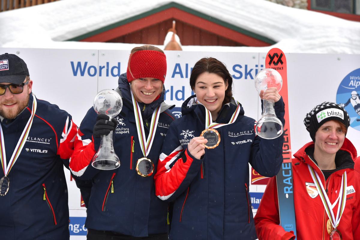 a female vision impaired skier and her guide on the podium