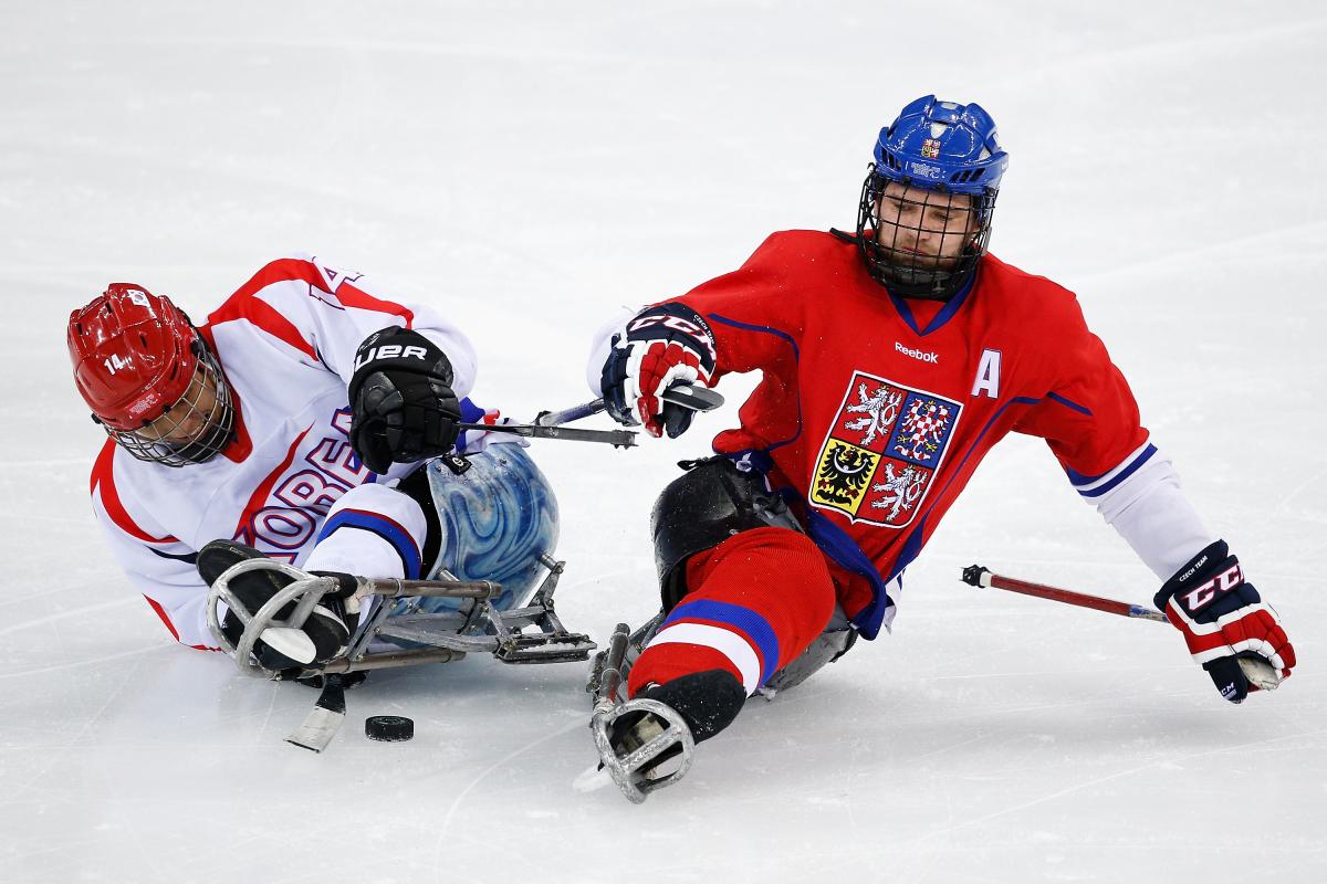 two Para ice hockey players clash on the ice