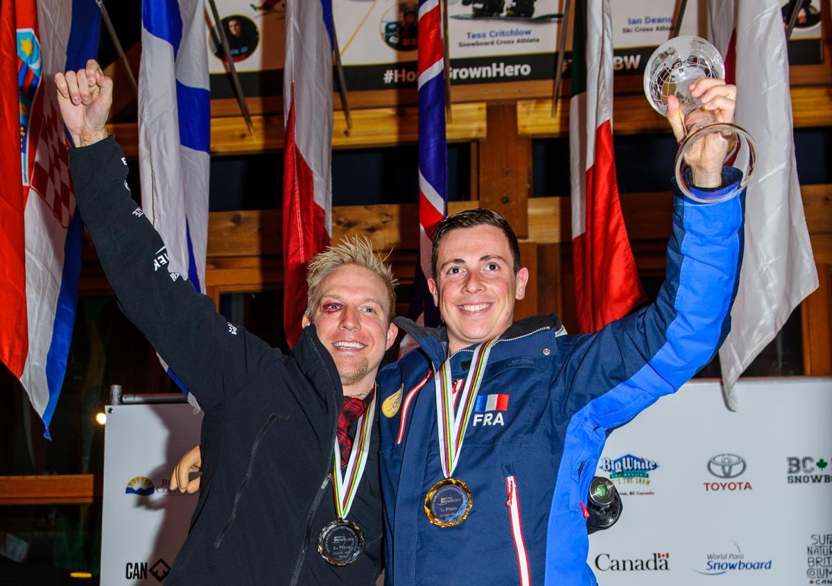 two male Para snowboarders on the podium with their medals