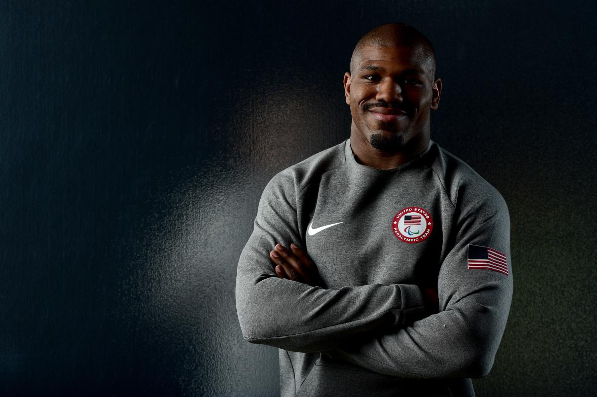 Dartanyon Crockett a male judoka smiles with his arms folded