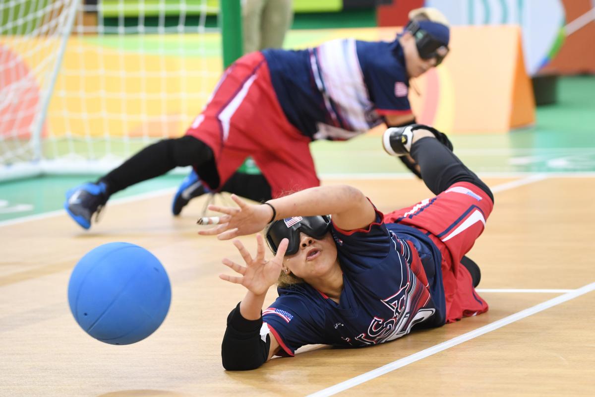 a female goalball player saves a shot