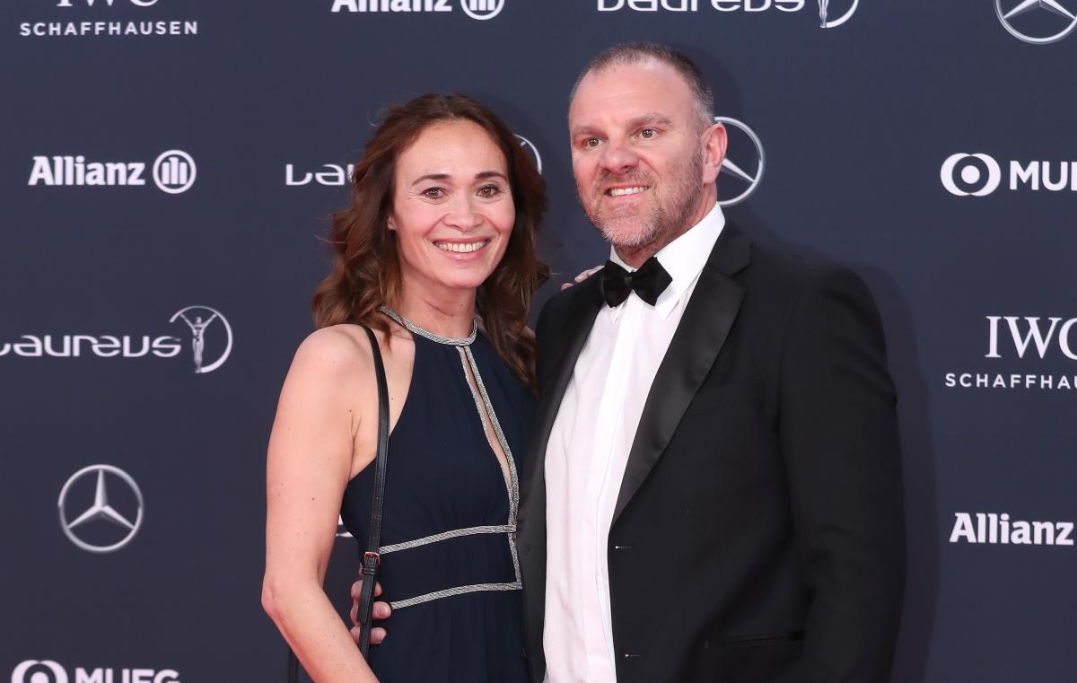 a woman and man stand on the red carpet