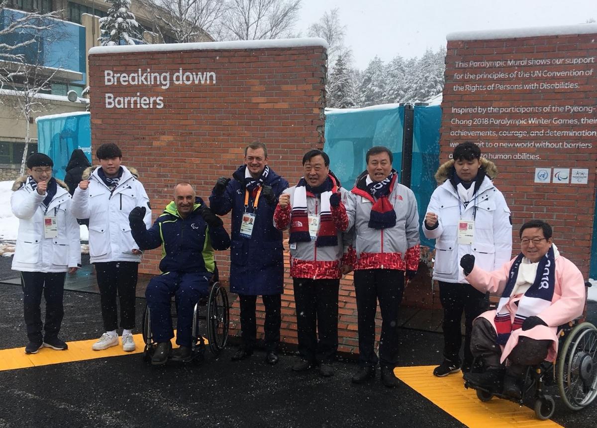 a group of people standing in front of a wall