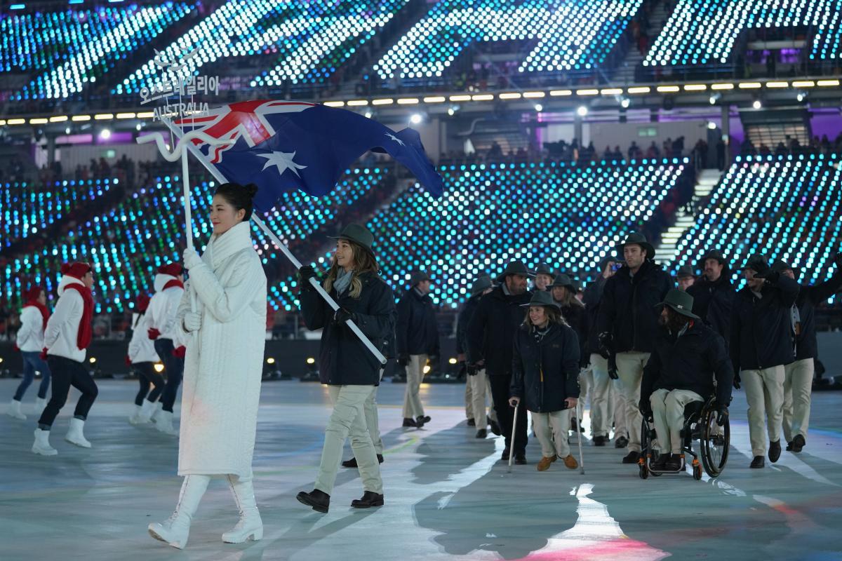 a female snowboarder carrying the flag of Australia