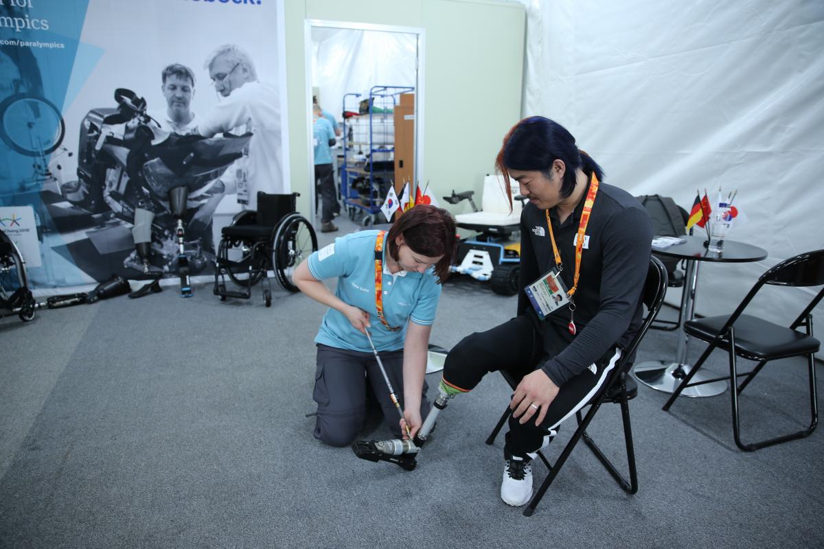 a woman works at repairing a prosthetic leg