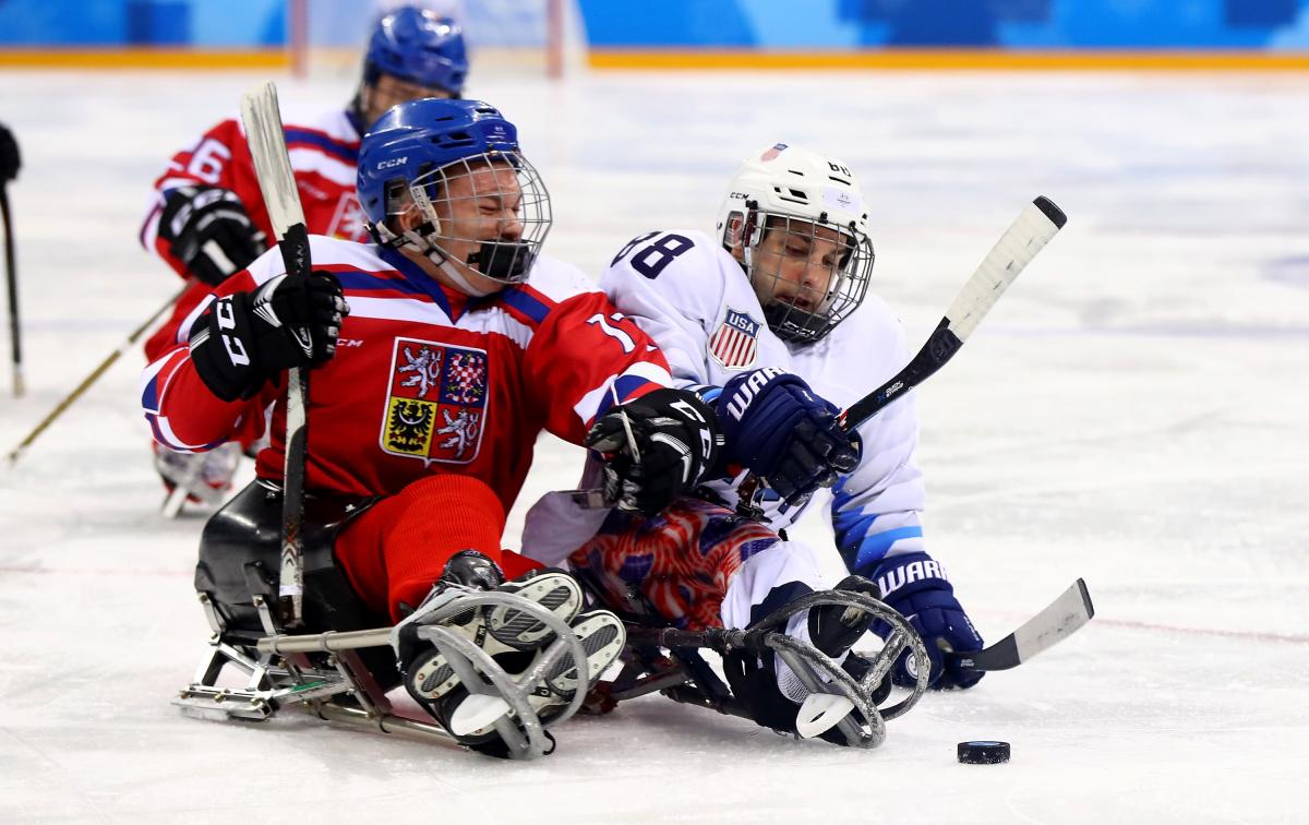 two Para ice hockey players clash on the ice