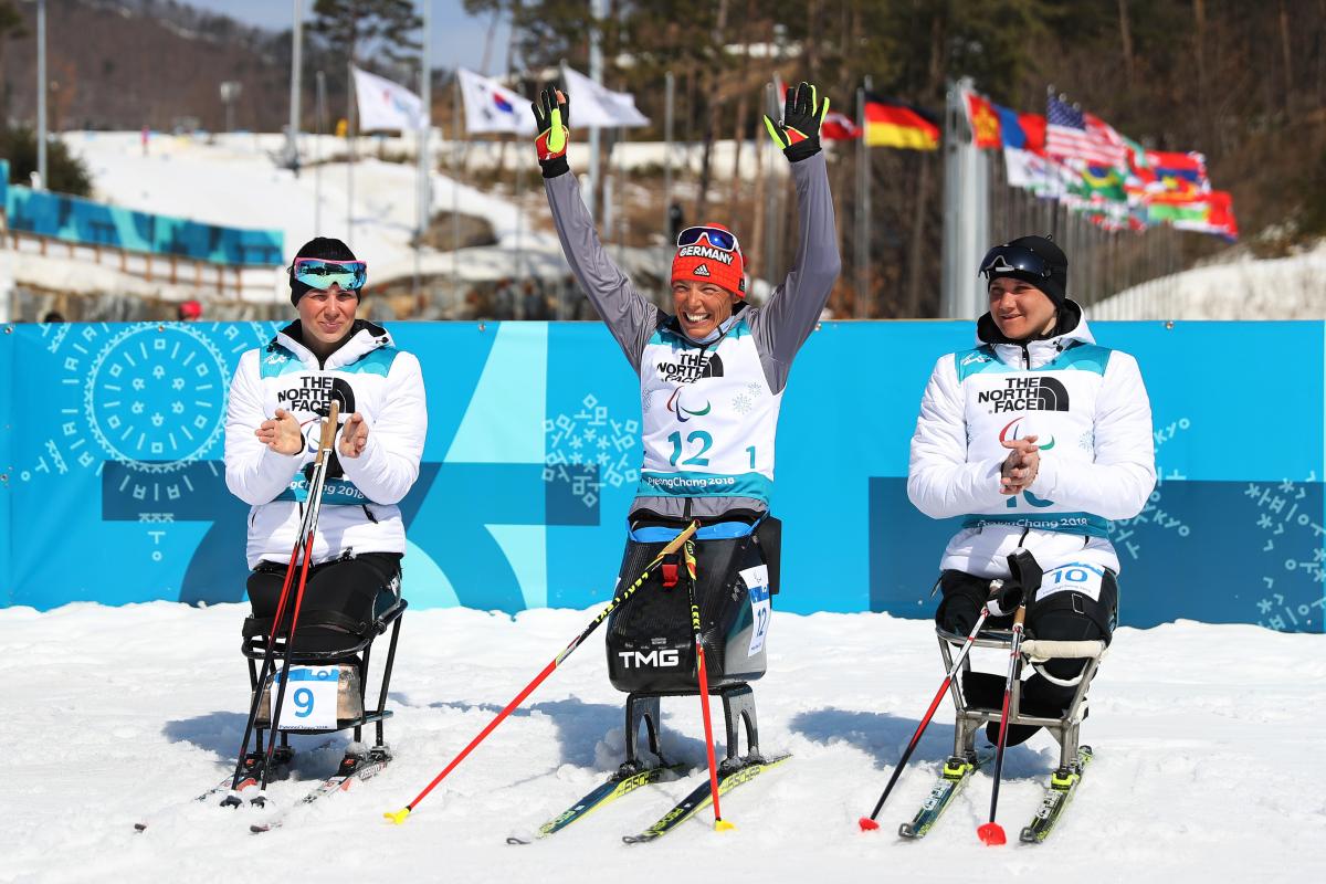 Germany's Andrea Eskau celebrates victory in the women's biathlon 10km sitting at PyeongChang 2018 with silver medallist Neutral Paralympic Athlete Marta Zainullina on the left and bronze medallist Neutral Paralympic Athlete Irina Gulaeva on the right.