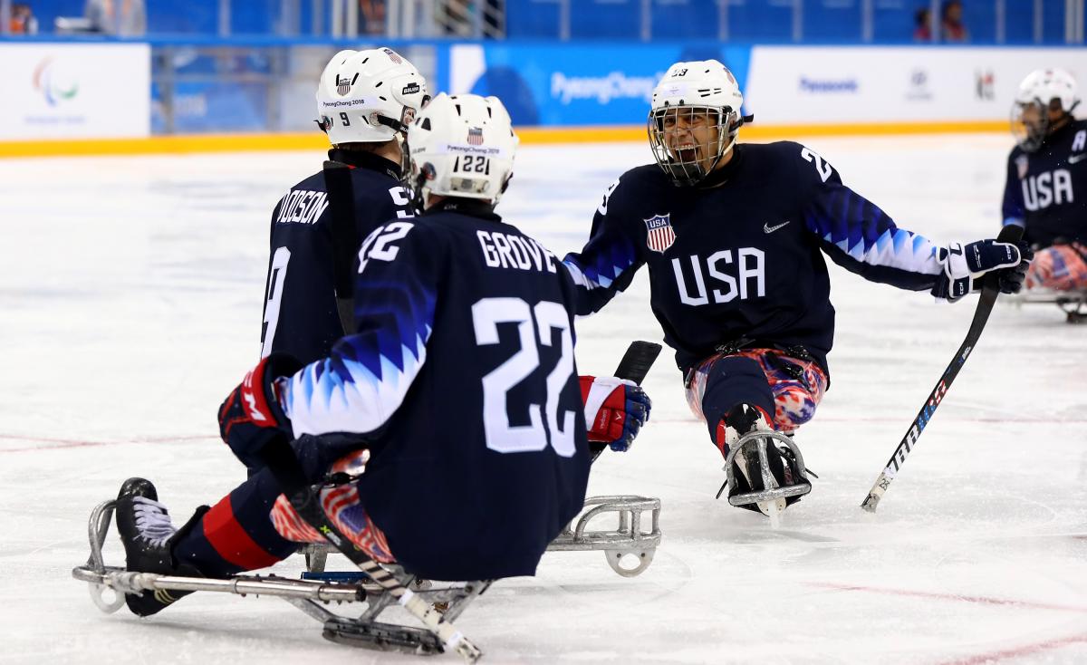 Para ice hockey players celebrate on the ice