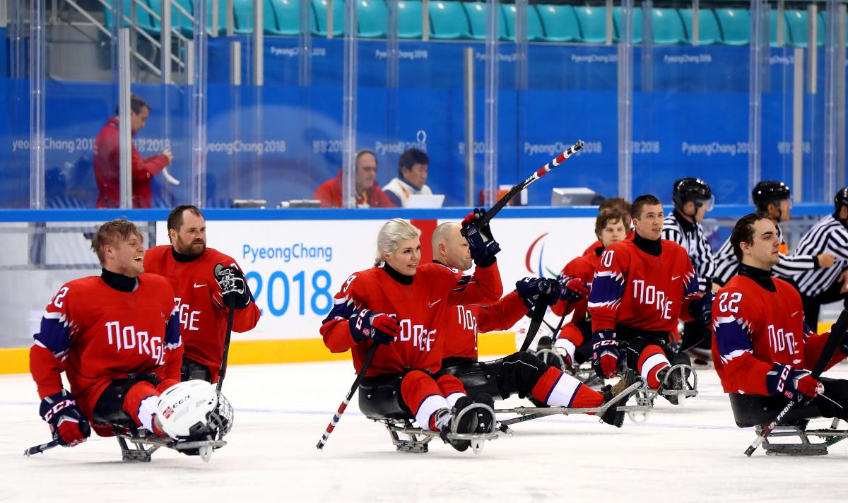 a group of Para ice hockey players celebrating the ice hockey