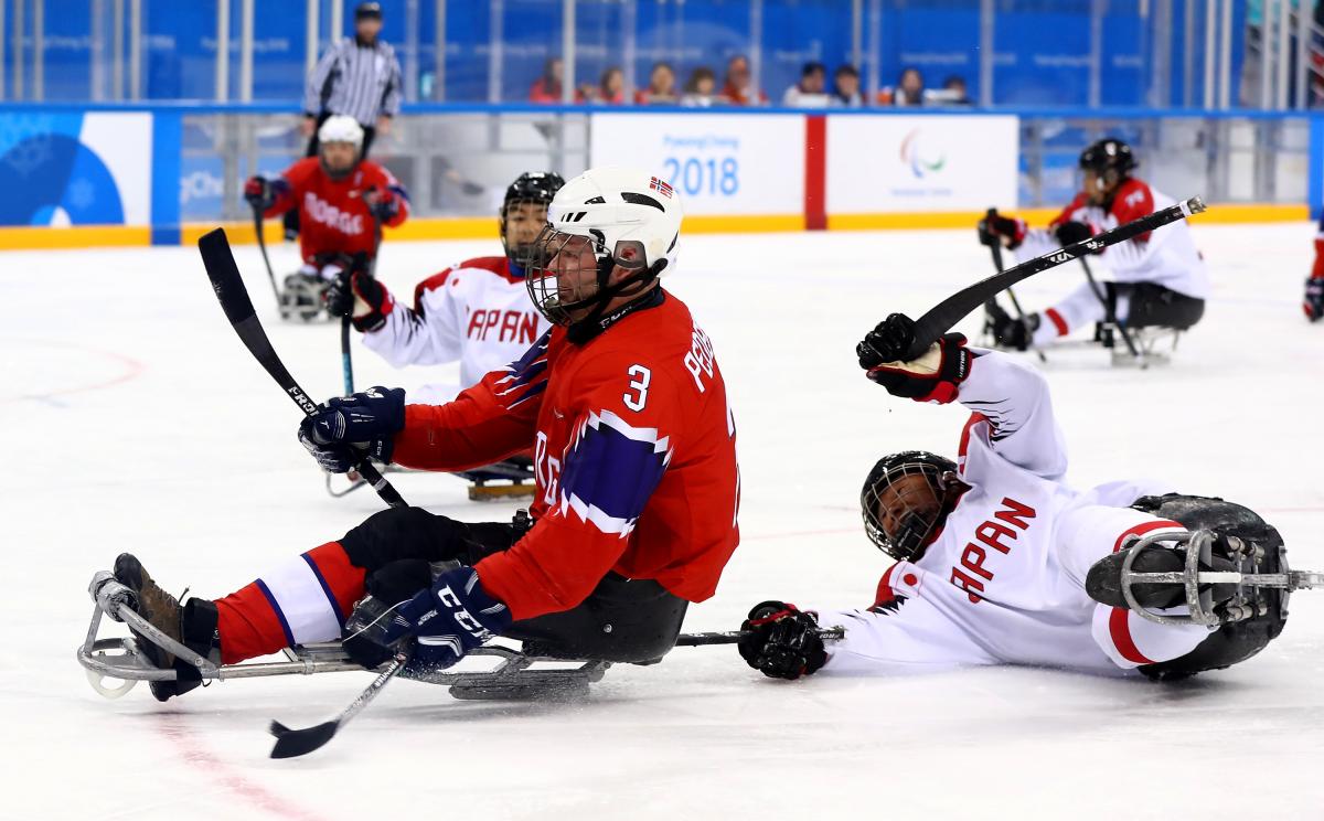 Para ice hockey players battling for the puck