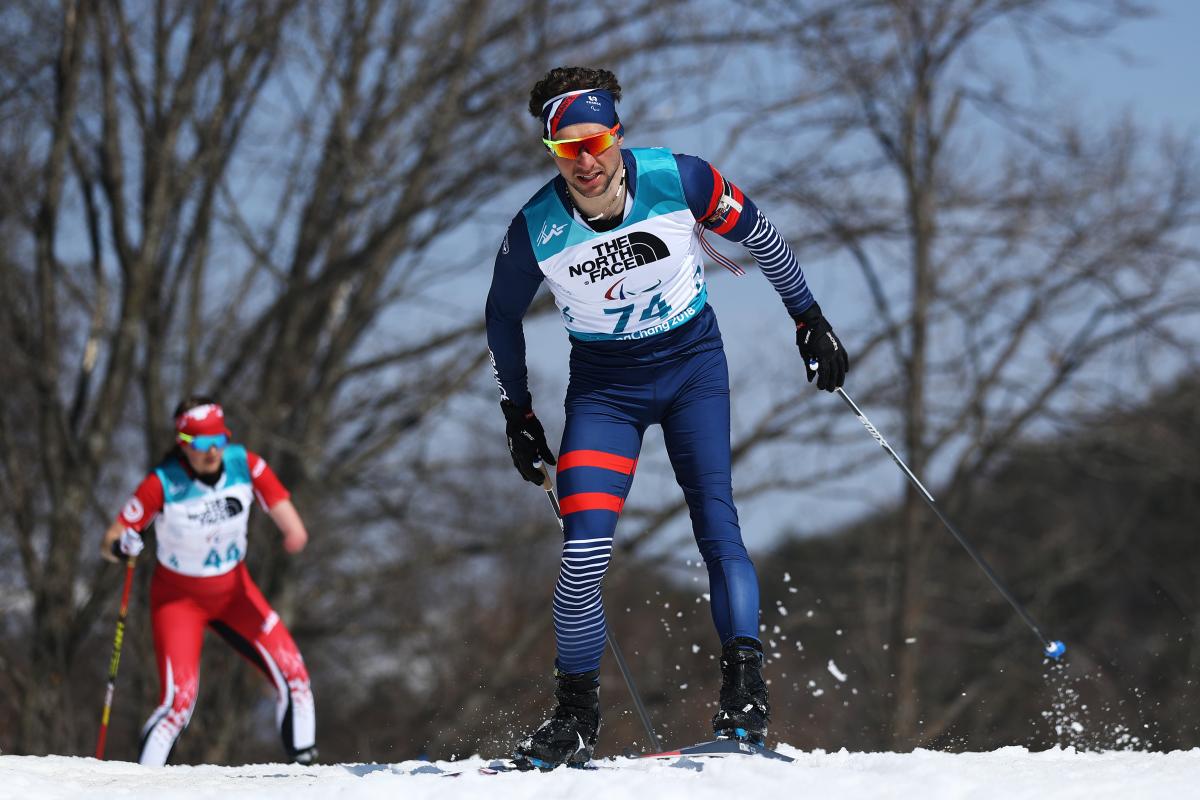 a male biathlete skies through the snow