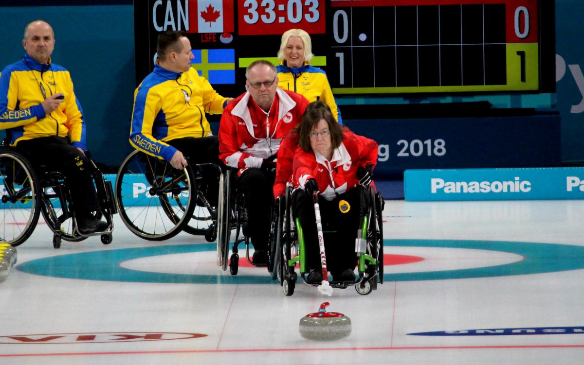 a female wheelchair curler plays a stone