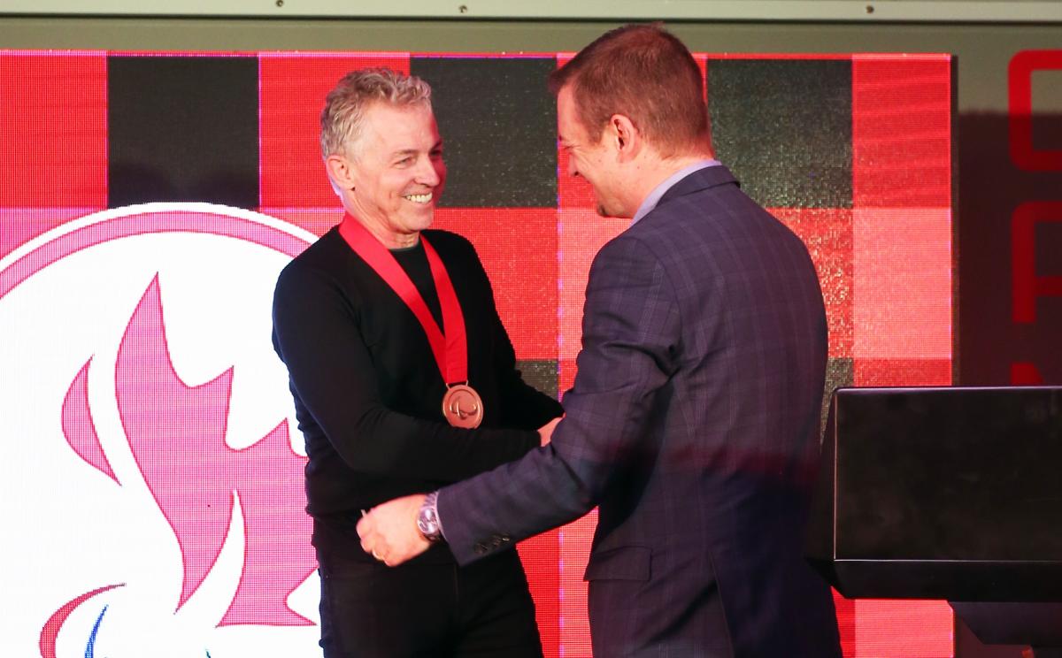 two men shaking hands and smiling