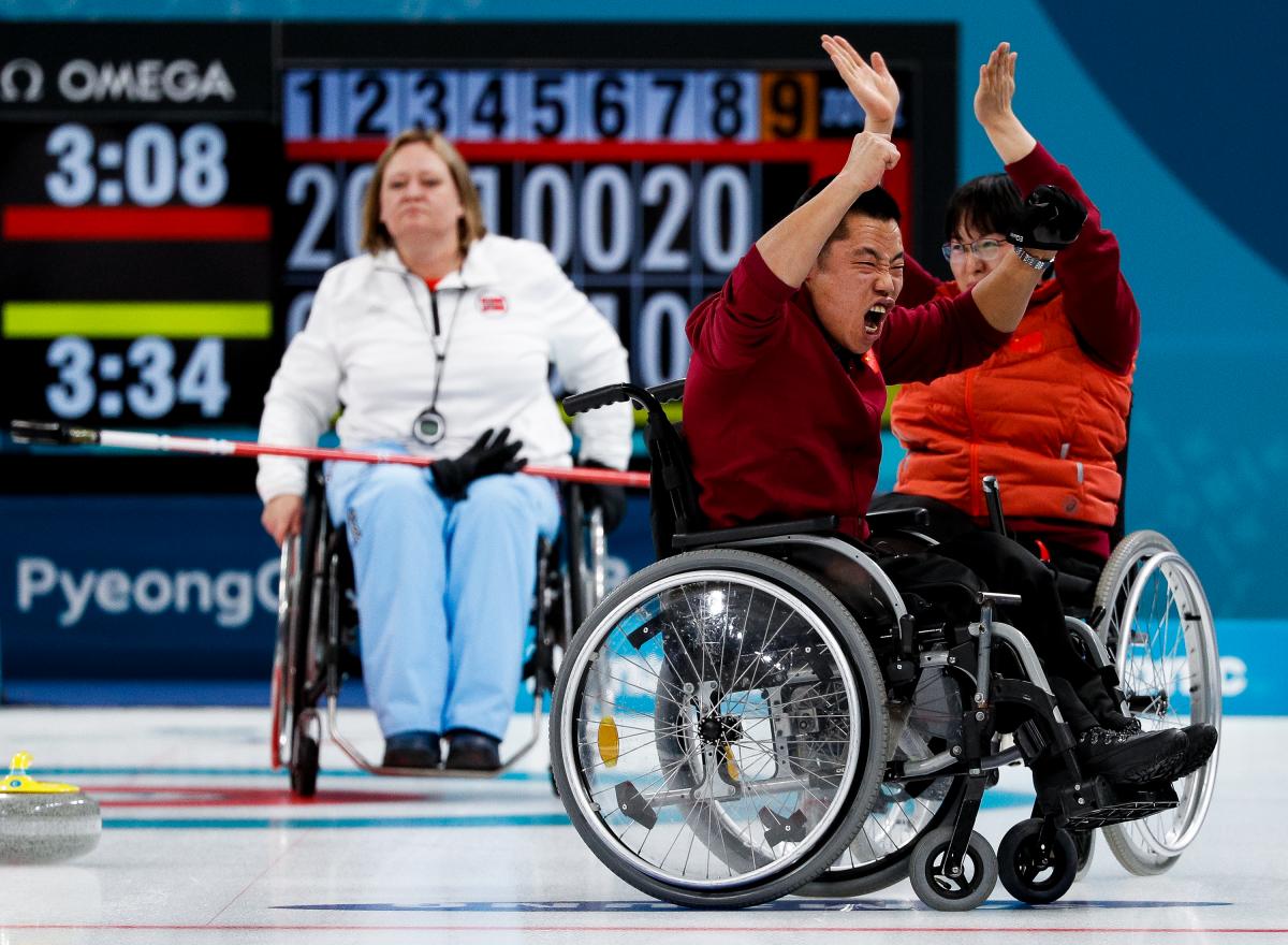 wheelchair curlers celebrating on the ice