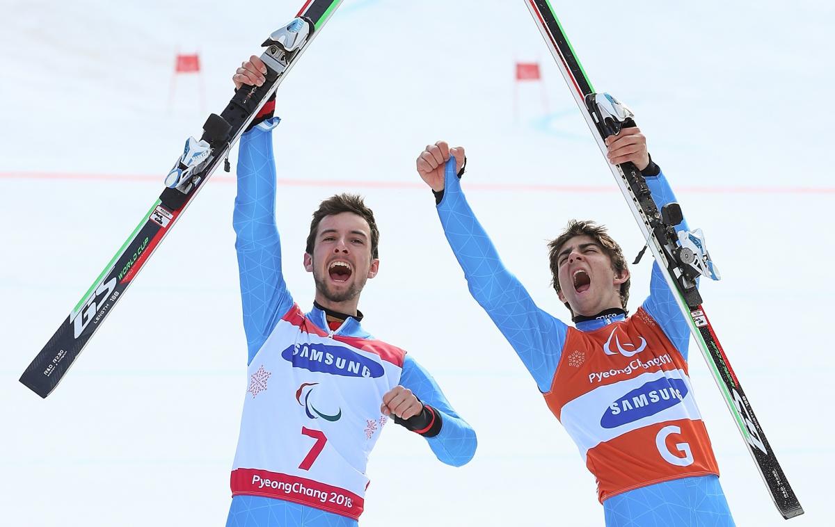 Giacomo Bertagnolli - PyeongChang 2018 a male vision impaired skier and his guide celebrate by holding up their skis